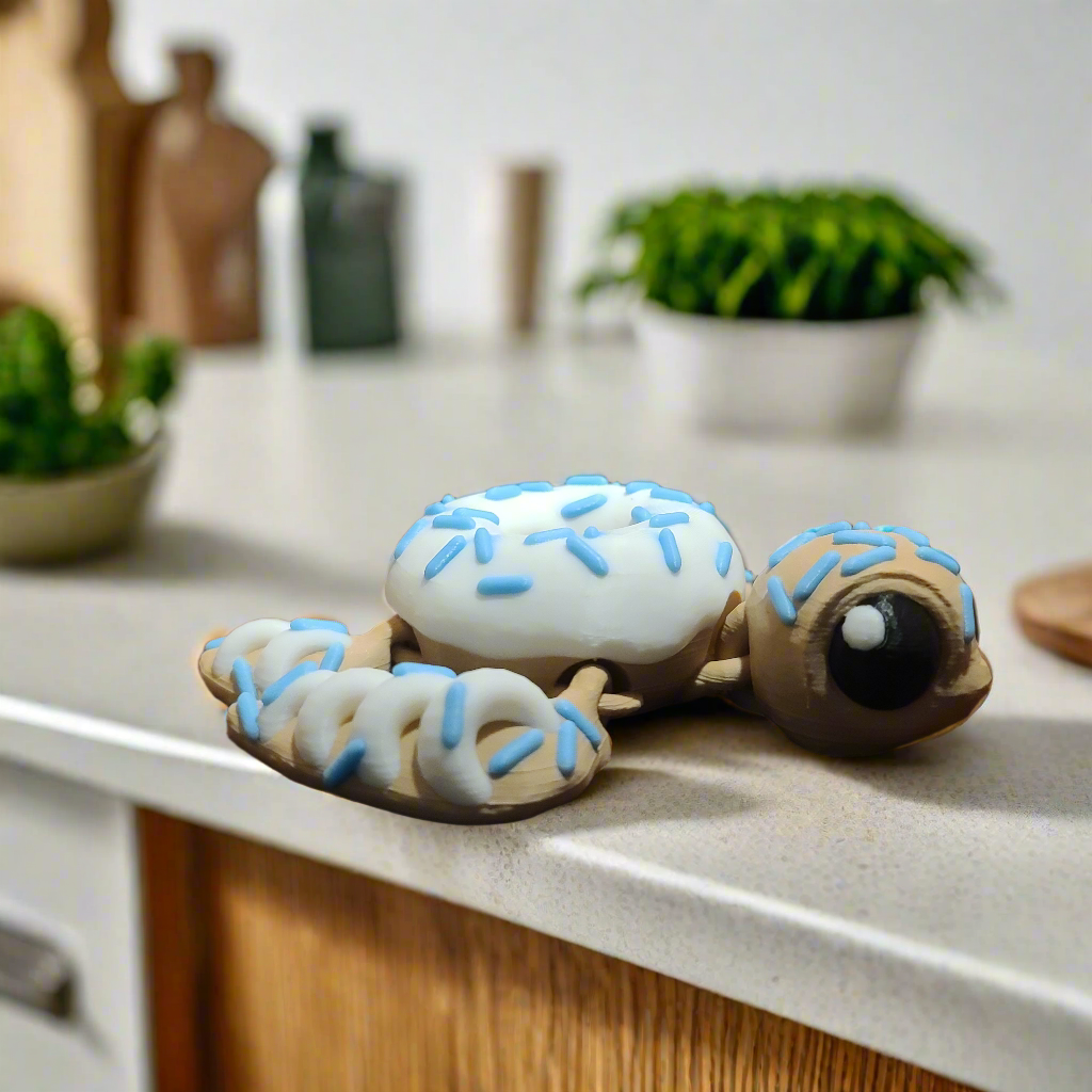 turtle with a doughnut shell with icing and blue sprinkles that glow in the dark.
