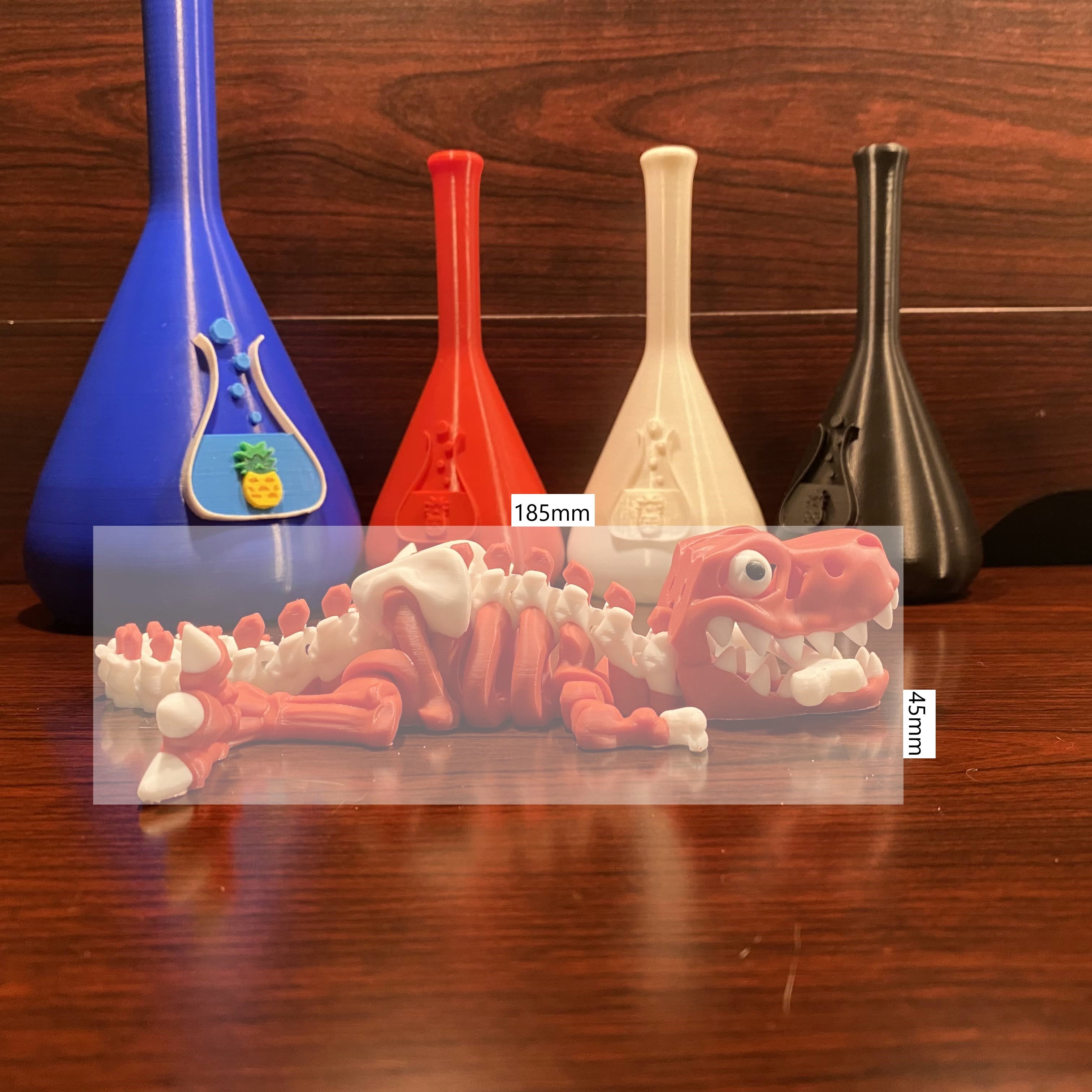 Red and white dinosaur with a bone in the mouth. 125x45mm scale overlayed. Wood background. Various beakers with chuganations logo nearby.