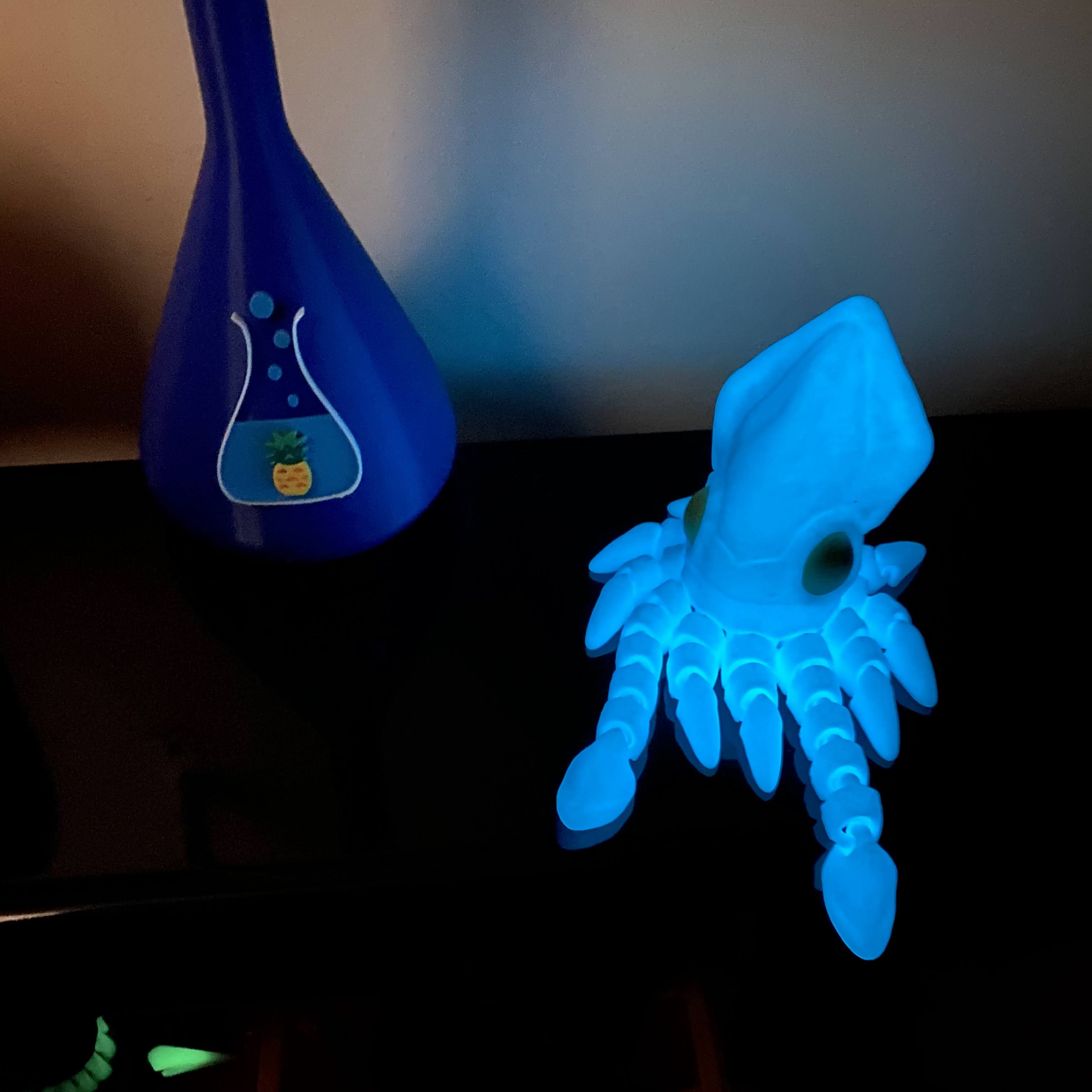 glowing blue squid fidget on a black shelf