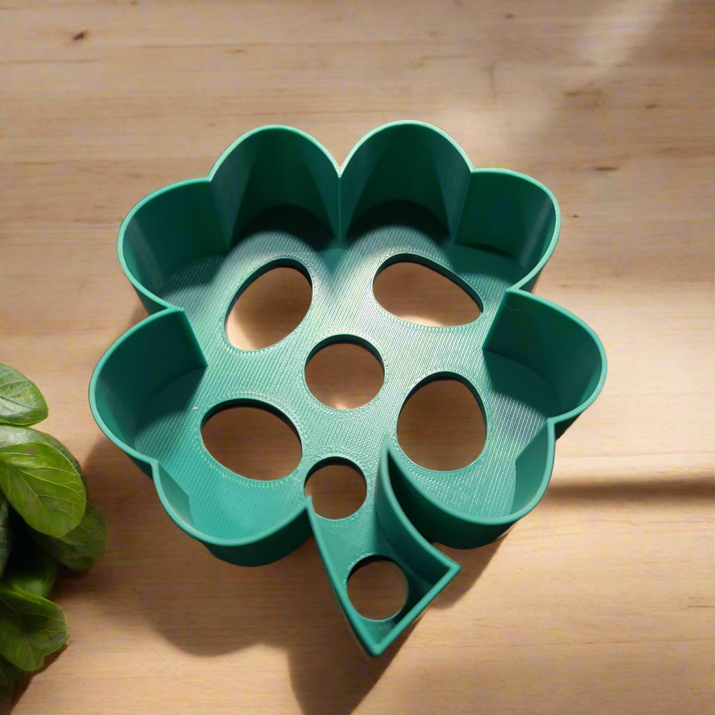 large cookie cutter shaped like a shamrock and colored green