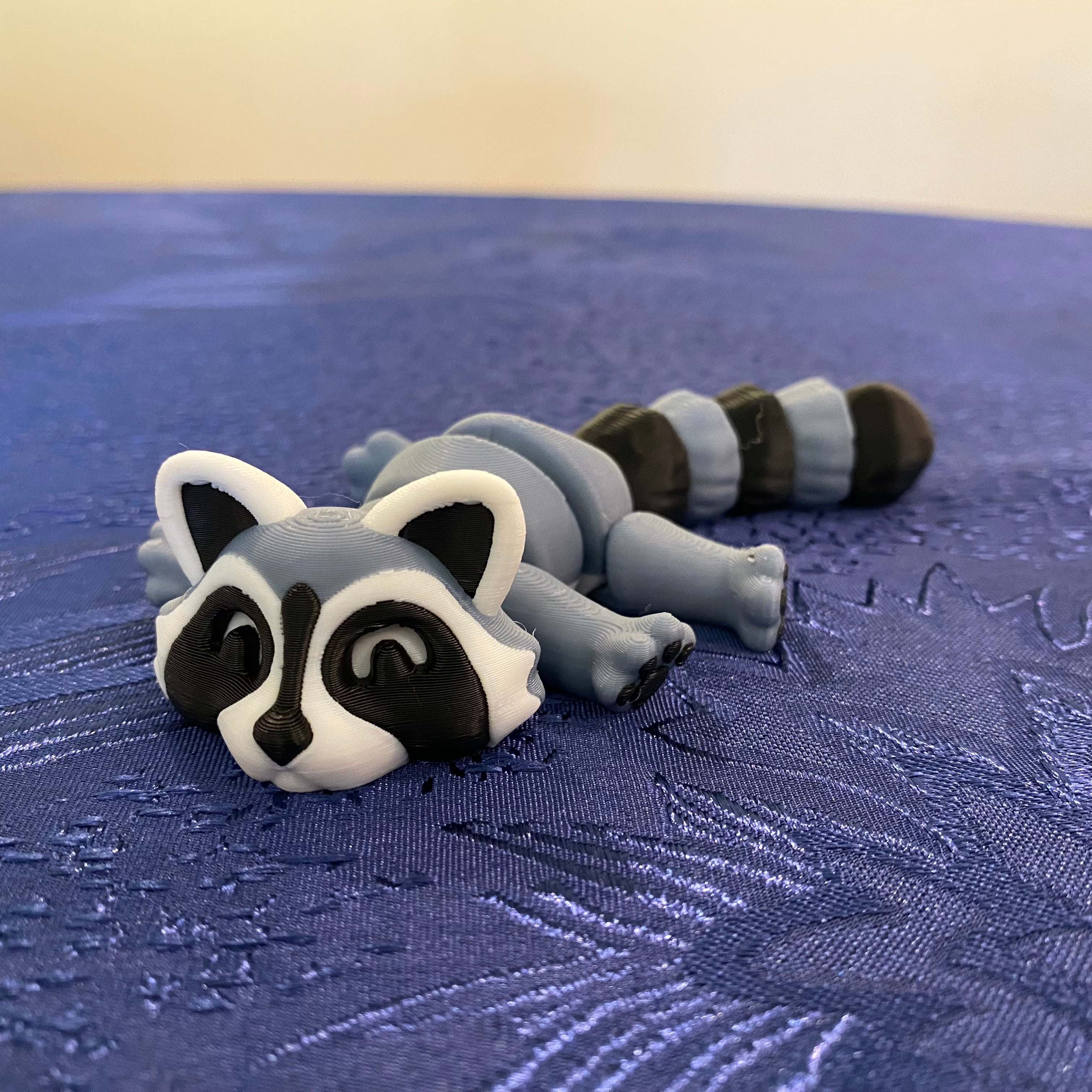 Model of a raccoon on a textured blue surface