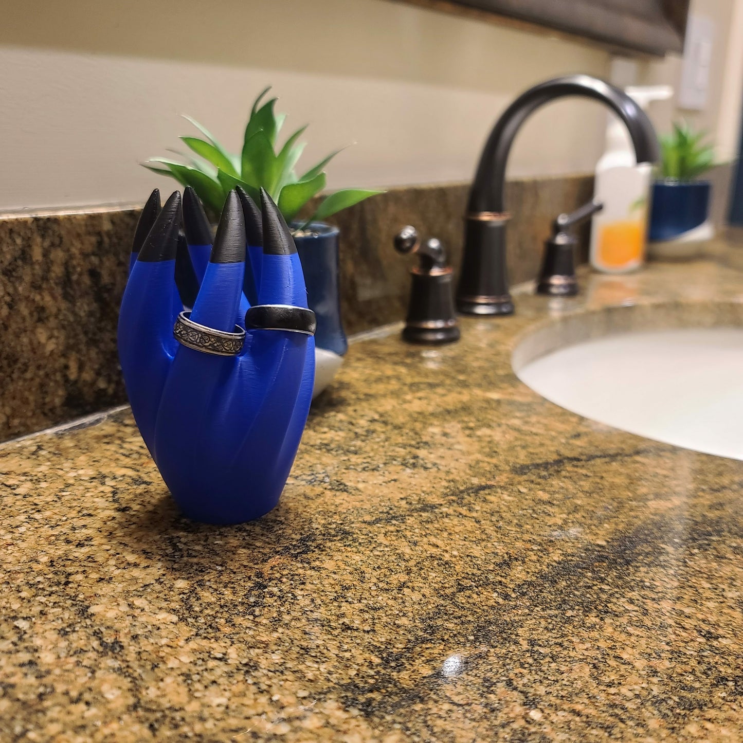 Ring holder on a bathroom counter. Holding two rings.