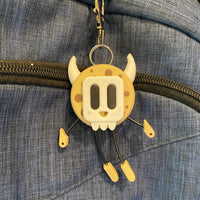 Cookie shaped keychain wearing a mask.