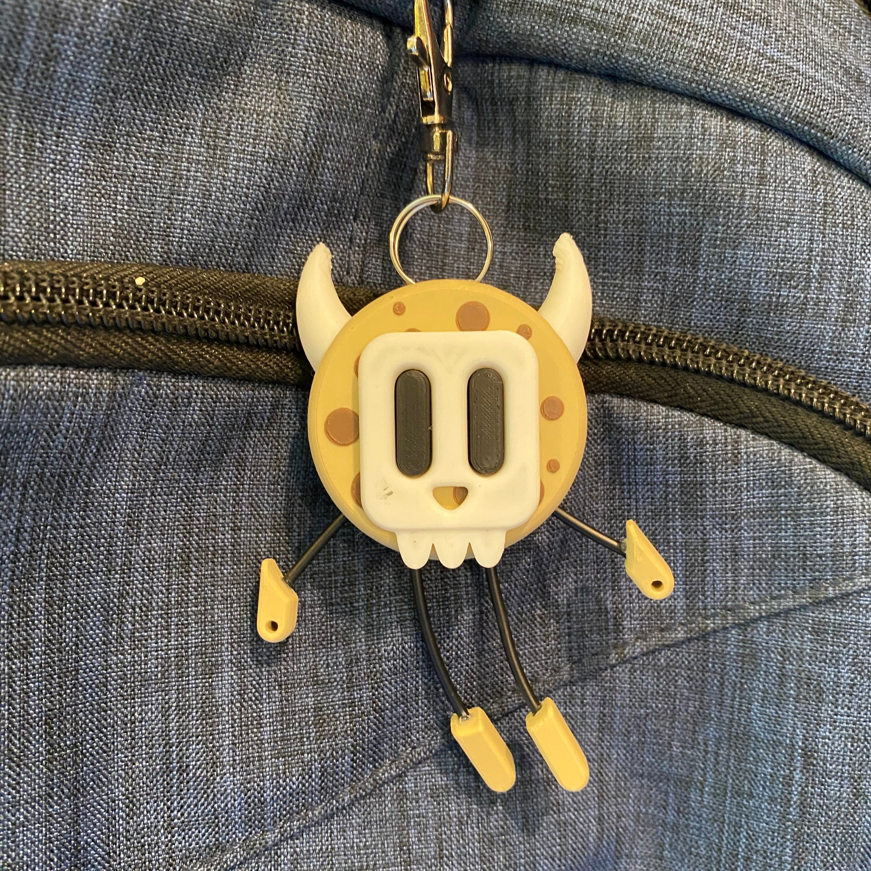 Cookie shaped keychain wearing a mask.