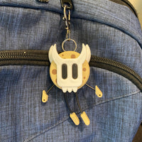 Cookie shaped keychain wearing a mask.