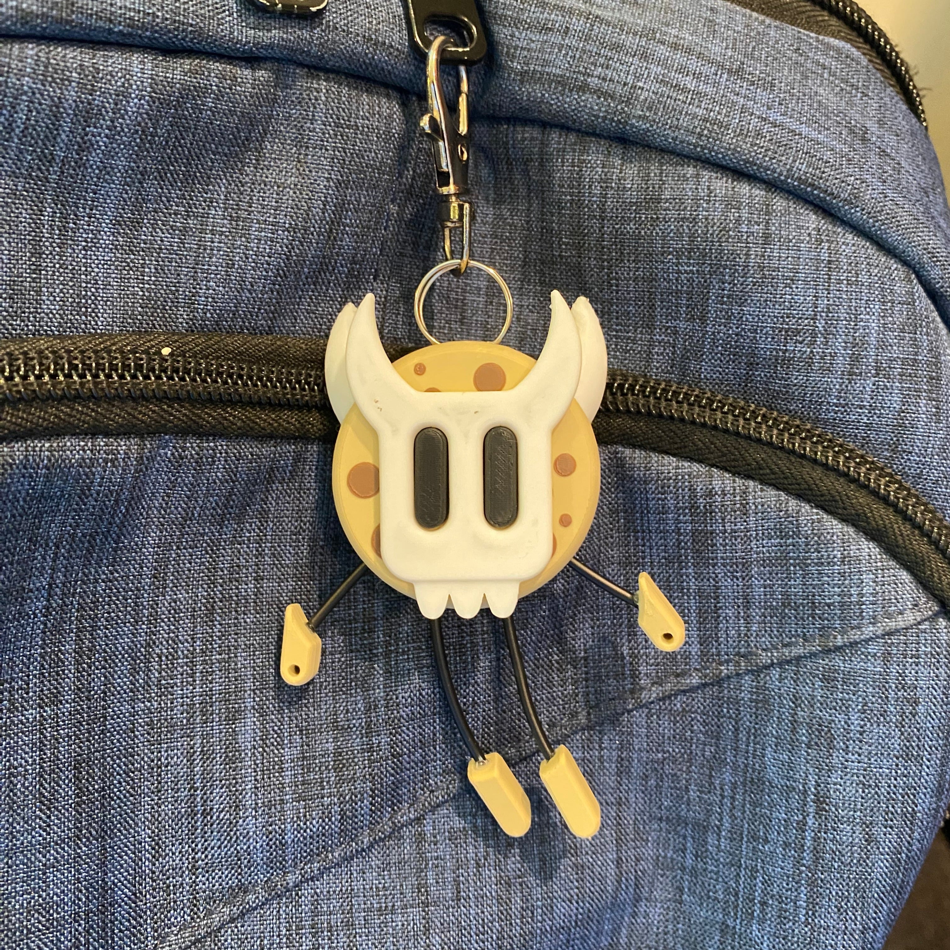 Cookie shaped keychain wearing a mask.
