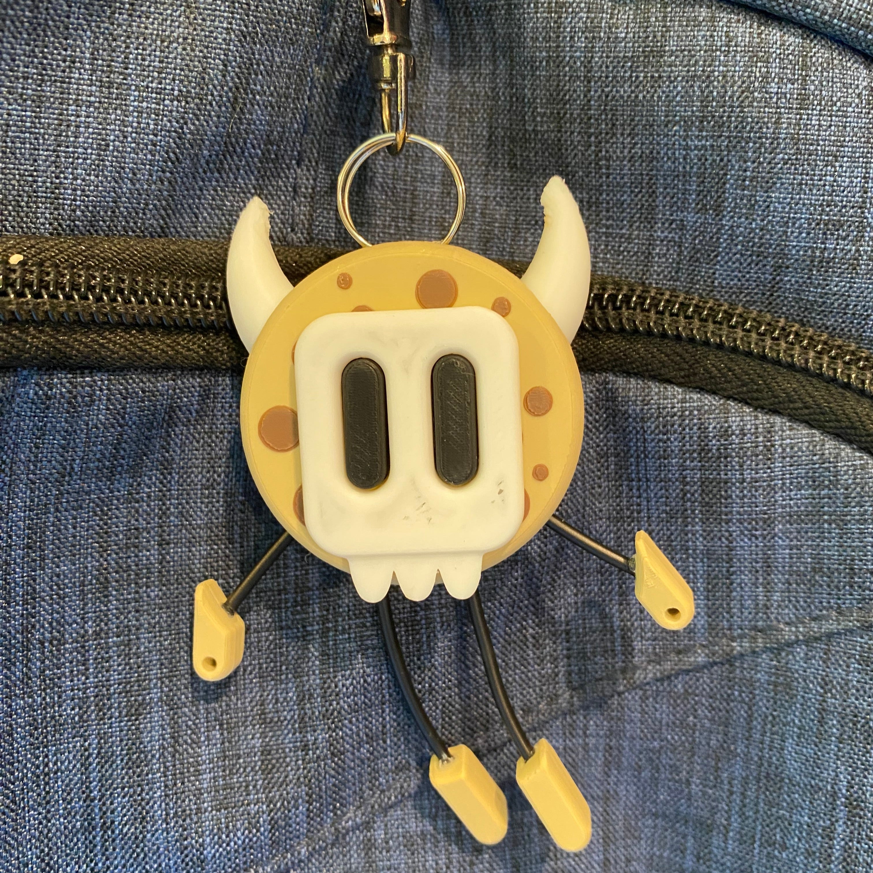 Cookie shaped keychain wearing a mask.