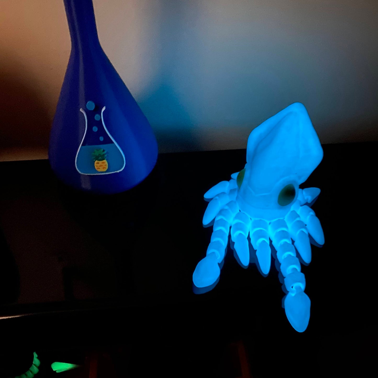 glowing blue squid fidget on a black shelf