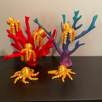 These golden octopi fidgets are cuties! 6 golden octopi are resting on a couple of corral reefs. All of the items in the photo are manufactured by Chuganation's 3D Lab.