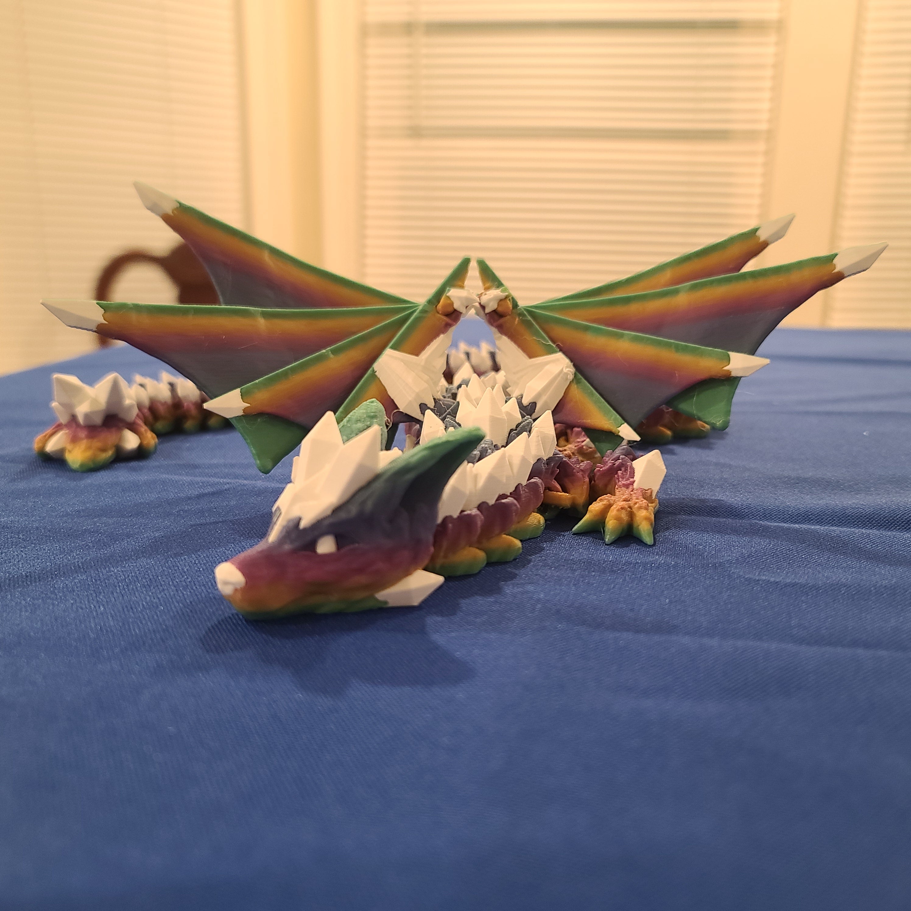 rainbow crystal wolf dragon on a blue tablecloth. dragon manufactured by chuganations 3d lab.